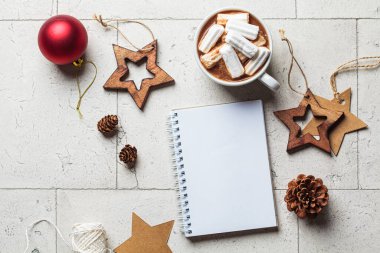 Noel ya da yeni yıl festivali geçmişi. Beyaz fincanda lokum, kurabiye, defter, noel süslemeleri, üst görünüm, fotokopi alanı, gri kaplama arkaplan.