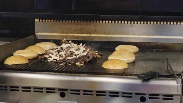 Chefs hands cooking chopped beef burgers with grilled onions in restaurant. Fast food concept. — Stock Video