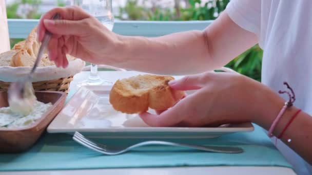 Woman eating bread with Greek dip Tzatziki in a restaurant. Mediterranean cuisine concept. — Stock Video