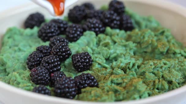 Ciotola di farina d'avena verde vegana con tè matcha, spirulina e more. — Video Stock