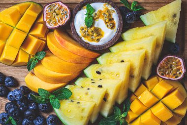 Tropik meyve şarküteri tatlı otlatma tabağı ahşap tahta üzerinde, koyu arka plan, üst manzara.