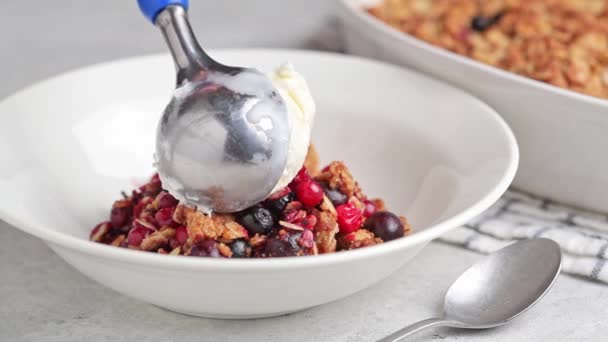 Tarta de cereza desmenuzada con una cucharada de helado en el plato. — Vídeo de stock