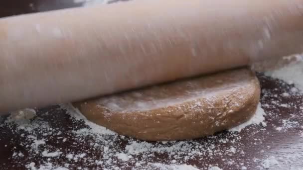 Rolar a massa de biscoito na mesa de madeira com um rolo. — Vídeo de Stock
