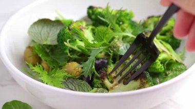 Izgara brokoli ve beyaz kasede zeytinli yeşil salata.. 