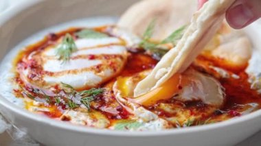 Beyaz kasede Türk yumurtaları. Yoğurt ve baharatlı tereyağı soslu haşlanmış yumurta..