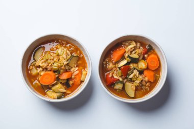 Vegetarian bean tomato soup with vegetables on a white background, top view.