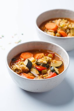 Vegetarian bean tomato soup with vegetables on a white background.
