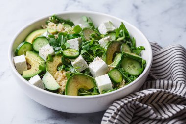 Green quinoa salad with cucumber, arugula, avocado and feta.