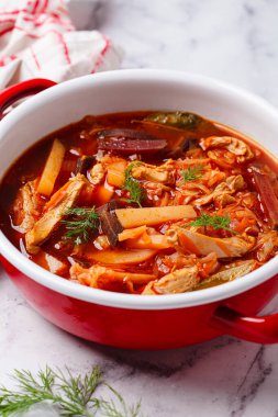 Klasik ev yapımı pancar çorbası. Kırmızı bir tencerede tavuk var..