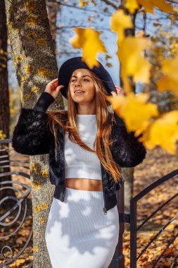 Akçaağaç yaprağıyla gülen güzel kız sonbahar akçaağaç ormanında