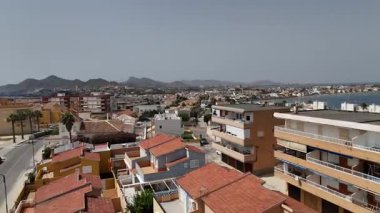 Cabo de Palos 'un hava aracı Murcia İspanya' daki kıyı evleri, plajlar, körfez suları ve etrafındaki dağları gösteriyor..