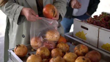 Müşterilerin taze narı plastik poşete koyup markette sağlıklı gıda alışverişi yapmalarına yakın durun.