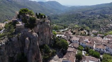 Yeşil vadiyle çevrili yüksek kayalık kayalıklarda şatosu olan antik dağ köyünün havadan görünüşü. Manzaralı İspanyol manzarası, tarihi mimari ve seyahat merkezi.