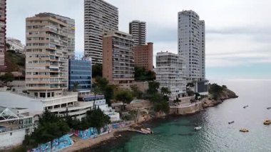Benidorm 'un gökyüzü manzarası kayalık sahillerde yüksek binalar ve turkuaz deniz. İspanya 'nın Akdeniz kıyısındaki sahil kentleri, tatil beldeleri ve daireleri.