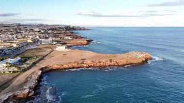 Güneşli bir günde İspanya 'nın kayalık kıyı şeridini uçurumlarla ve sakin Akdeniz' le gösteren insansız hava aracı görüntüsü.