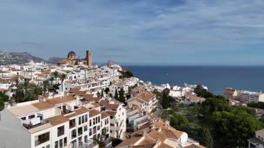 İspanya 'nın beyaz evleri, mavi kubbeli kilisesi ve Akdeniz' in güneşli bir günde Costa Blanca 'daki sahil köyünün insansız hava aracı görüntüsü.