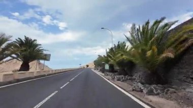 Tropikal arazide, palmiye ağaçları ve kayalık tepelerle dolu boş asfalt yol. Manzaralı seyahat rotası, yaz havası, özgürlük ve seyahat konsepti.