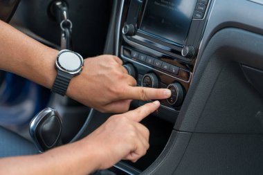 Modern araba panelinin klima ve klima kontrol düğmelerini ayarlayan elleri kapatın. Sürücü konforu, ulaşım ve otomotiv teknolojisi kavramı.