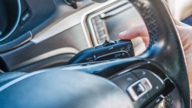 Gündüz sürüşü sırasında modern arabanın içindeki direksiyon direksiyonunun ön cam sileceği kolunu kapat.