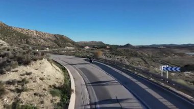 Kurak çöl manzarası, seyahat macerası ve özgürlük konsepti, manzaralı kırsal yolculuk boyunca dolambaçlı yol boyunca motosikletçinin hava manzarası
