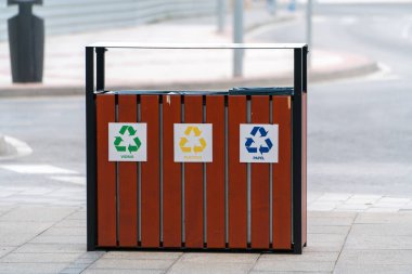 Şehir kaldırımında cam plastik ve kağıt atıkları için umumi geri dönüşüm kutuları. Atık ayırma ve çevre koruma kavramı.