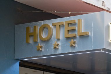 Bina cephesinde üç yıldızlı bir otel tabelası var. Misafirperverlik ve konaklama konsepti.