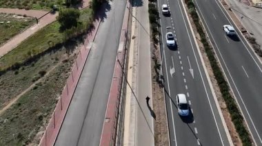 Çok şeritli otoban, hareket halindeki arabalar ve yaya yolu ile hava aracı görüntüsü. Kentsel ulaşım altyapısı ve trafik akışı kavramı.