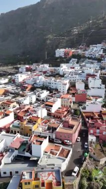 Garachico Tenerife Kanarya Adaları 'ndaki renkli evlerin hava aracı görüntüsü dramatik volkanik dağ manzarası ve geleneksel İspanyol mimarisi.