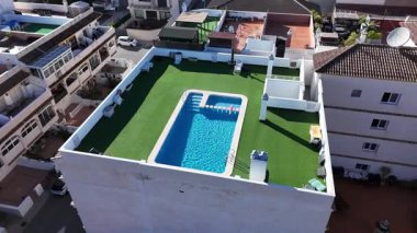 Güneşli bir günde İspanya 'nın San Miguel de Salinas kentindeki özel yüzme havuzlu, yeşil bahçeli ve Akdeniz evlerinin insansız hava aracı görüntüsü..