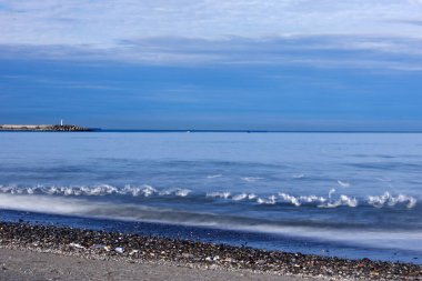 Turkuaz Deniz Buğusunun Kıyı Kayalıkları Etrafındaki Uzun Etkisi Koyu Doğal Kayalar ve Turkuaz Deniz Suyu 'nun ruhani sisli hareketi arasındaki zıtlık uzun pozlama tekniğiyle yakalanmıştır.
