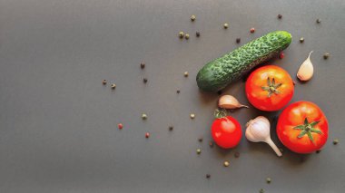 Domates, salatalık ve gri arka planda bir baş sarımsak kompozisyonu, yazı için yeri olan üst görünüm. Yüksek kalite fotoğraf