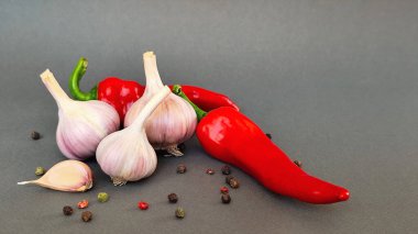 Biber, kırmızı biber ve sarımsak kompozisyonu gri arka planda, üst görünümde yazı için boşluk. Yüksek kalite fotoğraf