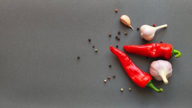 Biber, kırmızı biber ve sarımsak kompozisyonu gri arka planda, üst görünümde yazı için boşluk. Yüksek kalite fotoğraf
