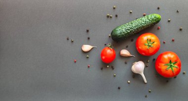 Domates, salatalık ve gri arka planda bir baş sarımsak kompozisyonu, yazı için yeri olan üst görünüm. Yüksek kalite fotoğraf