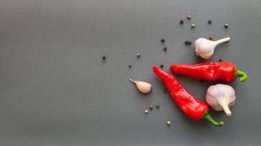 Biber, kırmızı biber ve sarımsak kompozisyonu gri arka planda, üst görünümde yazı için boşluk. Yüksek kalite fotoğraf