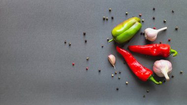 Biber, kırmızı biber ve sarımsak kompozisyonu gri arka planda, üst görünümde yazı için boşluk. Yüksek kalite fotoğraf