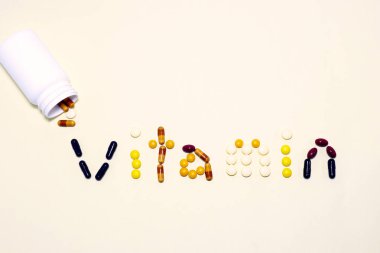 Vitaminler ve takviyeler vanilya renkli arka planda 