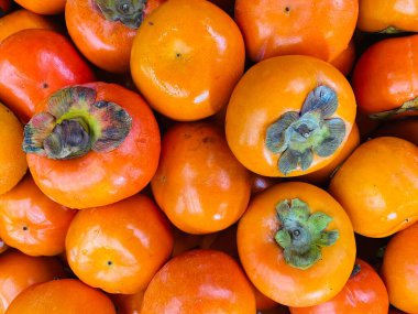 Persimmons 'ın marketteki yakın plan fotoğrafı. Meyve arkaplan grubu.