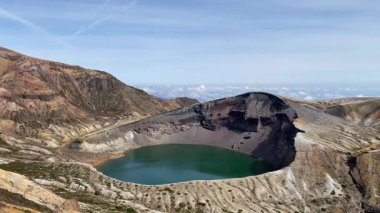 Okama Krateri Gölü güneşli bir günde. Yerel halk ona sevgiyle Okama derken, ziyaretçiler ona 