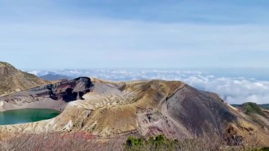Okama Krateri Gölü güneşli bir günde. Yerel halk ona sevgiyle Okama derken, ziyaretçiler ona 
