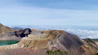 Okama Krateri Gölü güneşli bir günde. Yerel halk ona sevgiyle Okama derken, ziyaretçiler ona 