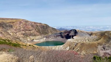 Okama Krateri Gölü güneşli bir günde. Yerel halk ona sevgiyle Okama derken, ziyaretçiler ona 