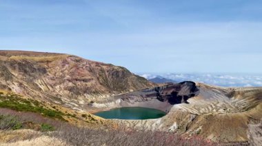 Okama Krateri Gölü güneşli bir günde. Yerel halk ona sevgiyle Okama derken, ziyaretçiler ona 