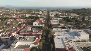 Santa Barbara şehir merkezinde düzgün bir hava görüntüsü. Manzara, okyanusa doğru uzanan State Street Gezinti Alanı 'nı, uzaktaki dükkanları, palmiye ağaçlarını ve kıyı şeridini gösteriyor. Klip, bu kıyı şehrinin rahat atmosferini yakalıyor..