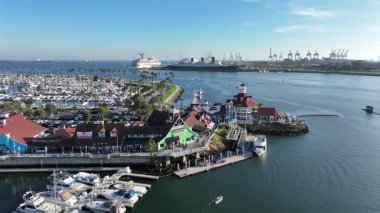 Long Beach, California, ABD - Long Beach limanına yanaşmış tarihi Queen Mary okyanus gemisiyle kıyı şeridini gösteren hava aracı görüntüsü, liman parkları, marina suları ve Güney Kaliforniya kıyı şeridi ile çevrili.