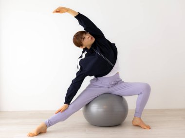 Güzel genç bayan pilates egzersizi yapıyor. 