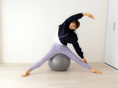 Güzel genç bayan pilates egzersizi yapıyor. 