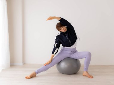 Güzel genç bayan pilates egzersizi yapıyor. 