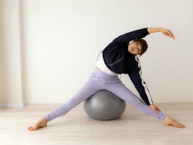 Güzel genç bayan pilates egzersizi yapıyor. 