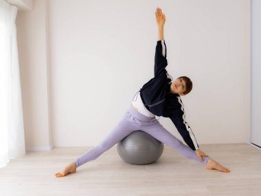 Güzel genç bayan pilates egzersizi yapıyor. 